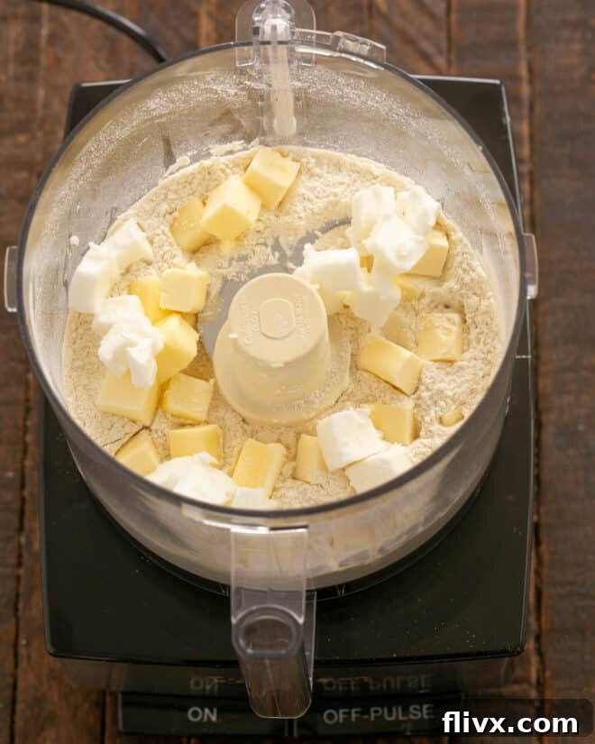 Step 2: Cold, cubed butter and shortening are added to the dry ingredients in the food processor.