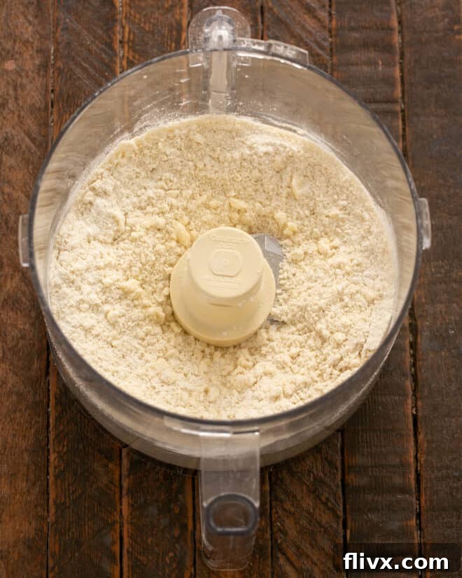 Step 3: The butter and shortening are pulsed into the dry ingredients until the mixture resembles coarse cornmeal with some pea-sized fat chunks.