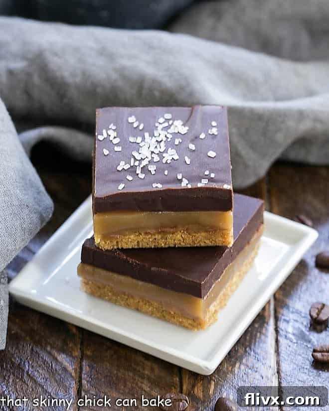 Close-up of Caramel Espresso Bars stacked on a square white plate, showing the rich chocolate and caramel.
