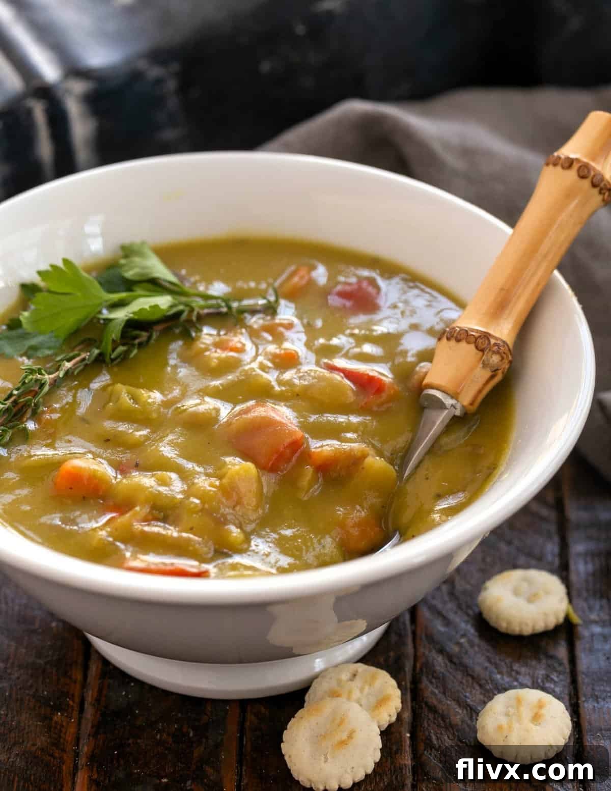 A bowl of creamy split pea and ham soup, garnished with fresh herbs, ready to be enjoyed.