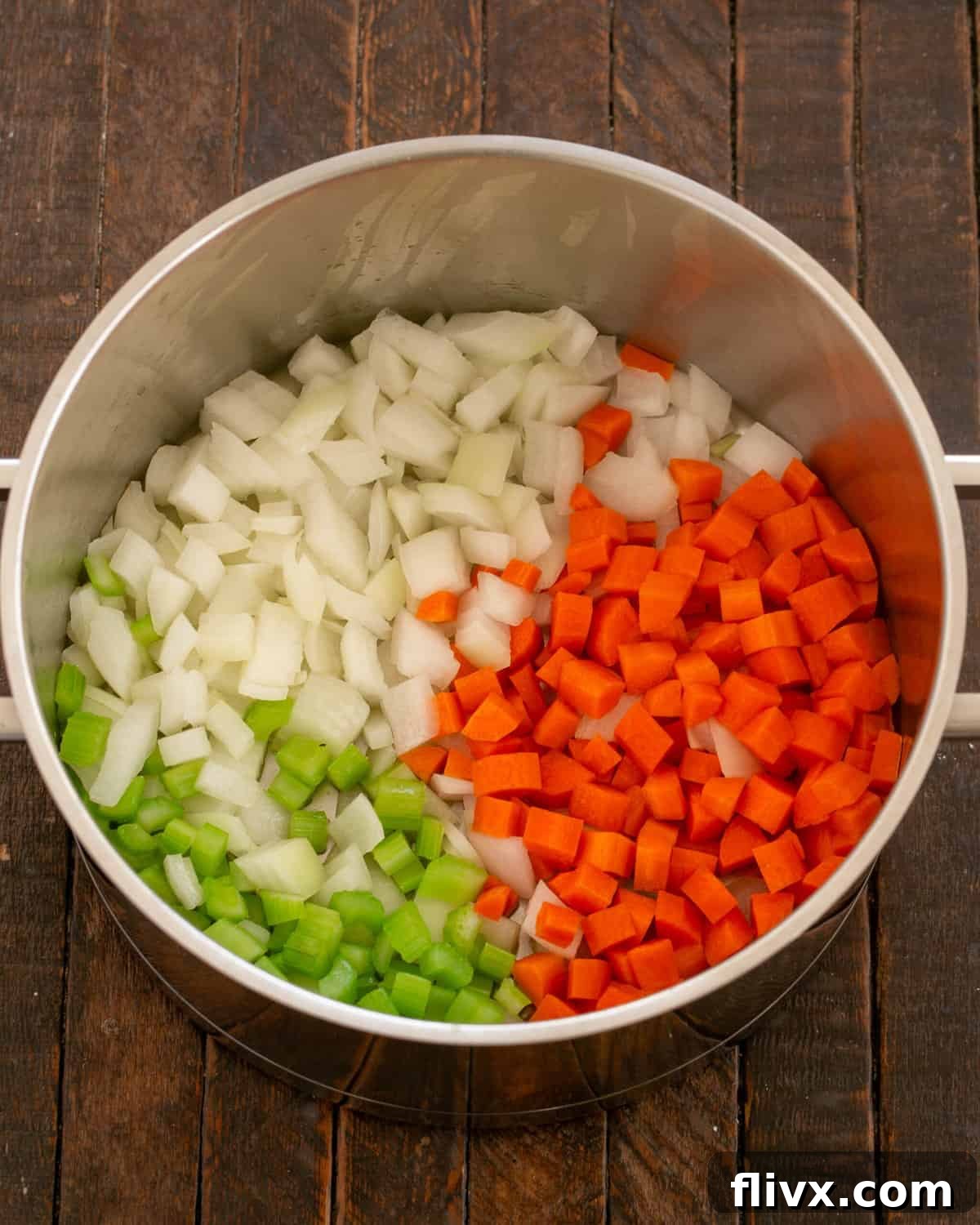 Sautéing onions, carrots, celery, and diced ham in olive oil in a skillet.