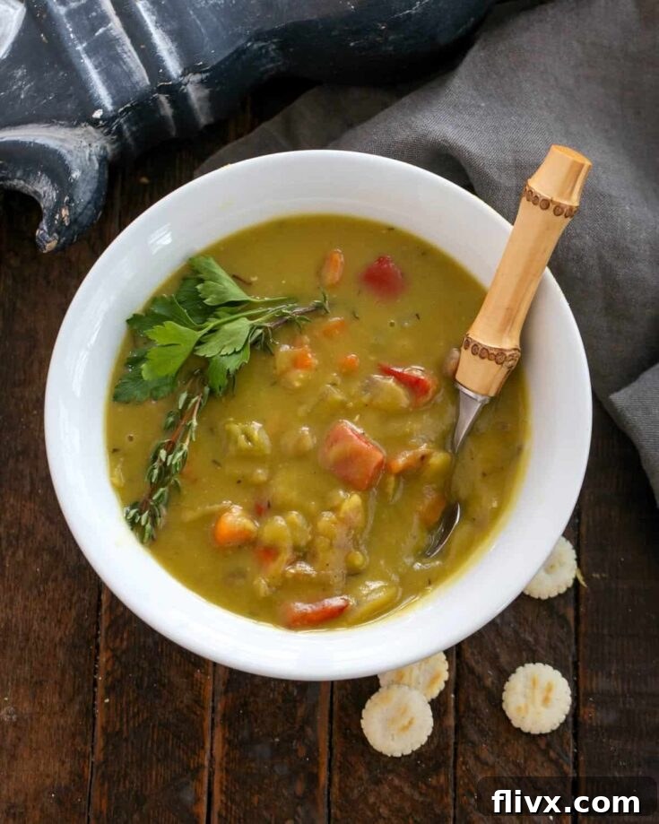 Overhead of split pea soup in a white bowl with a bamboo handle spoon.