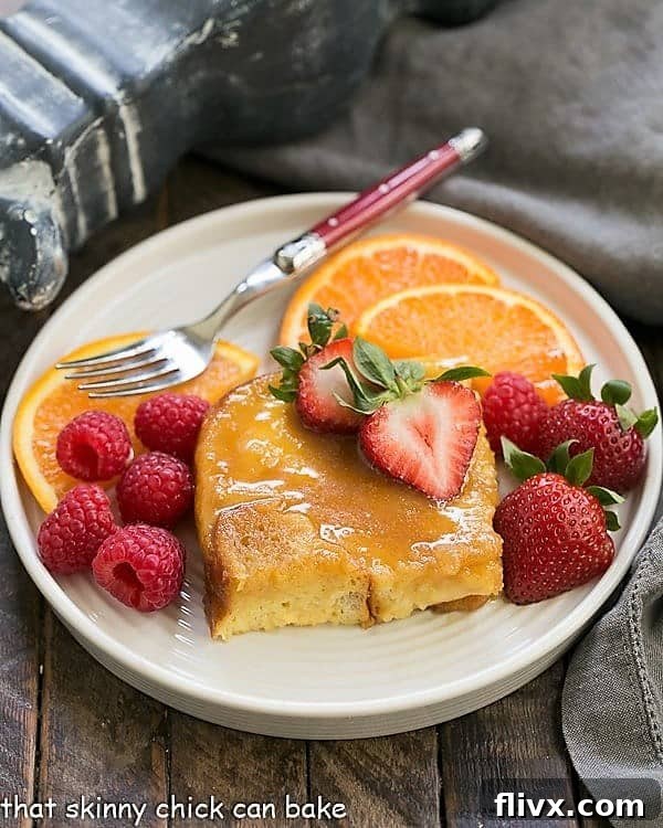 Crème Brûlée French Toast on a round plate with fruit and a red handled fork.
