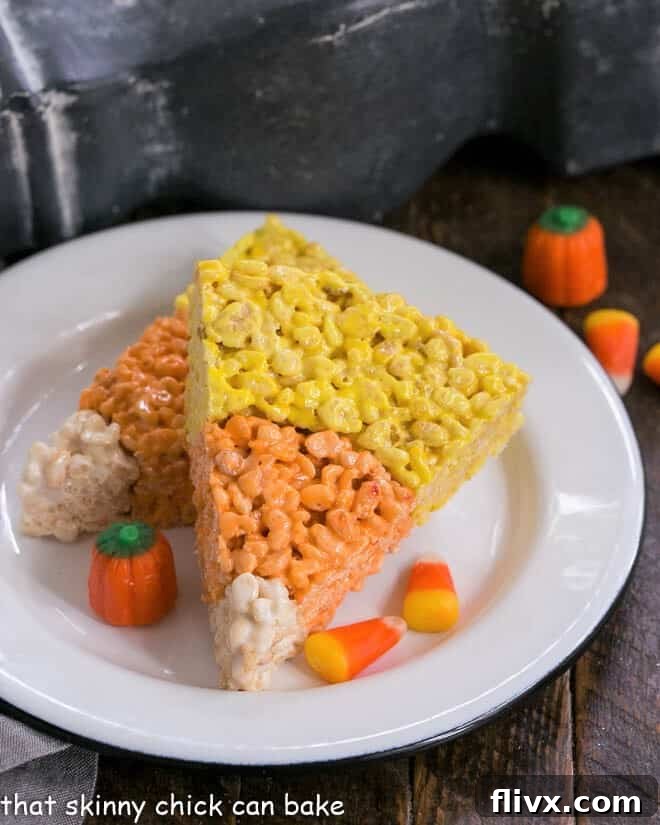 Vibrantly colored Candy Corn Rice Krispie Treats arranged beautifully on a round white plate, ready for Halloween festivities.