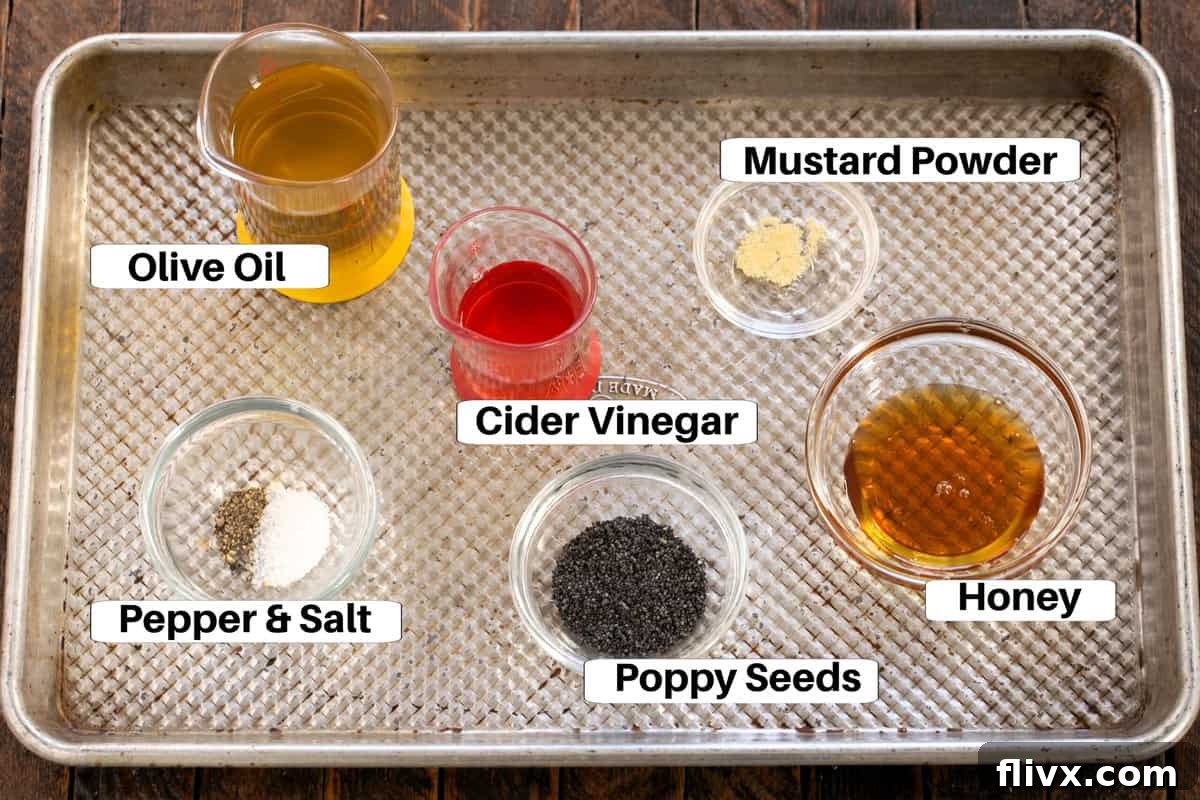 A collection of spinach salad dressing ingredients, including olive oil, vinegar, honey, and poppy seeds, neatly arranged on a sheet pan with labels.