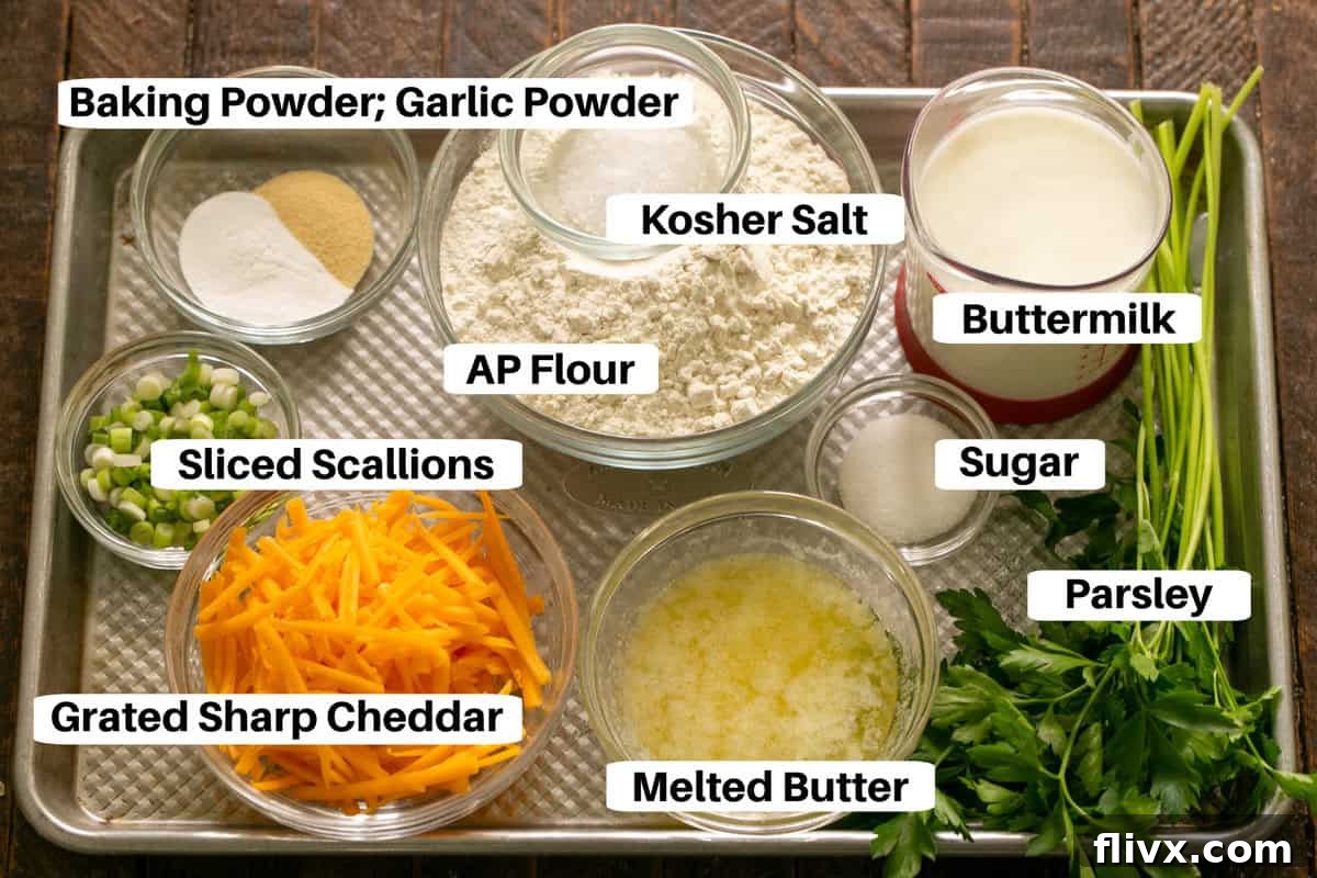 All the ingredients for Cheddar Herb Biscuits are laid out on a sheet pan, clearly labeled for easy identification.