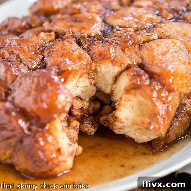 Close-up of golden brown Apple Monkey Bread with caramel glaze on a serving platter.