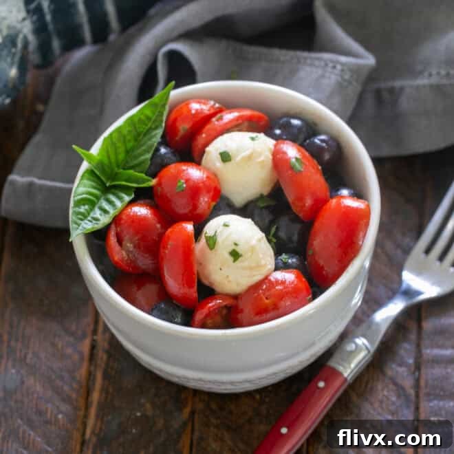 Caprese Salad Tossed with Vinaigrette and garnished with Basil.