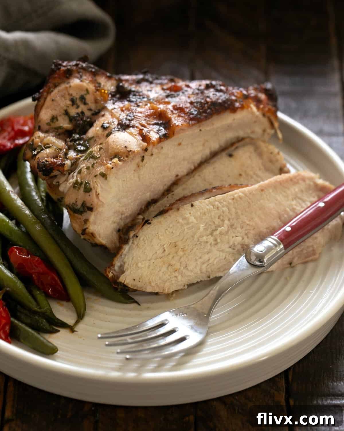 Grilled Chicken Piccata on a dinner plate with a lemon slice and fresh parsley garnish.
