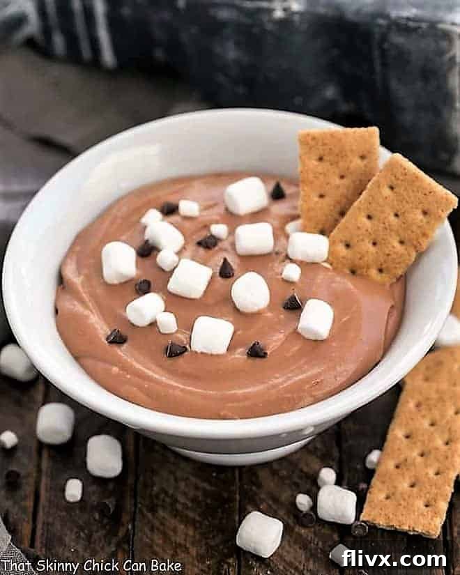 An Easy S'mores Dessert Dip served with graham cracker dippers, showing gooey melted marshmallows and chocolate.