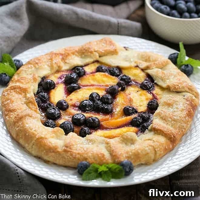 A rustic Peach Blueberry Galette, showcasing fresh peaches and blueberries on a golden-brown pastry crust.