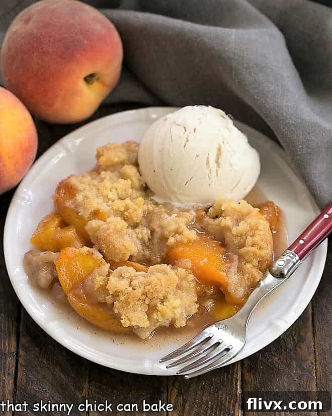 A serving of Classic Peach Crisp, topped with a scoop of melting vanilla ice cream.