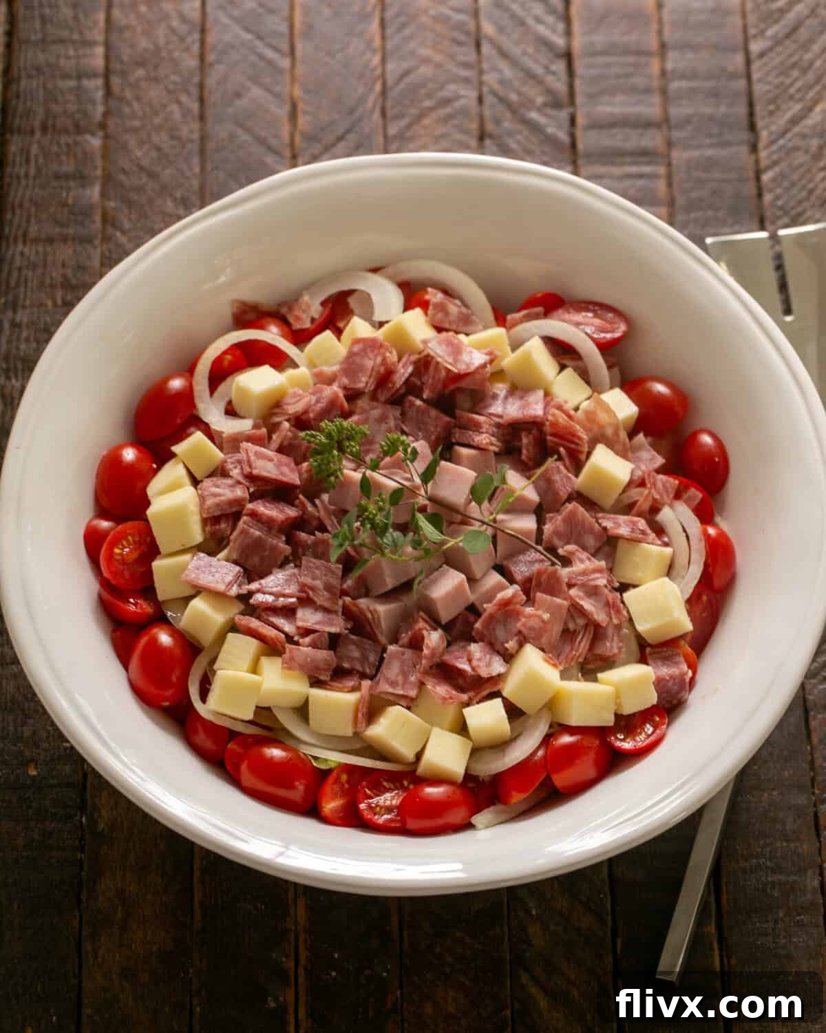 Overhead view of chopped salad in a white serving bowl.