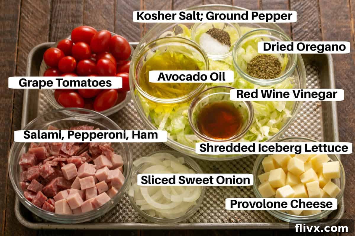 Italian sub chopped salad ingredients with labels on a metal sheet pan.