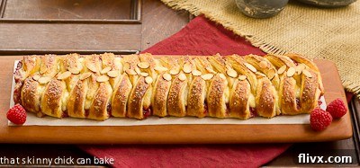 Raspberry Danish Braid - Tender dough filled with raspberry and cream cheese. Plus how to make a cheater laminated dough! A close-up horizontal view of the Raspberry Danish Braid, highlighting the intricate folding and the tempting filling peeking through.
