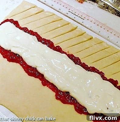 Homemade Danish Braid - Tender dough filled with raspberry and cream cheese. Plus how to make a cheater laminated dough! A close-up view detailing the cutting process for the Raspberry Danish Braid, showing parallel slits along the dough before braiding.