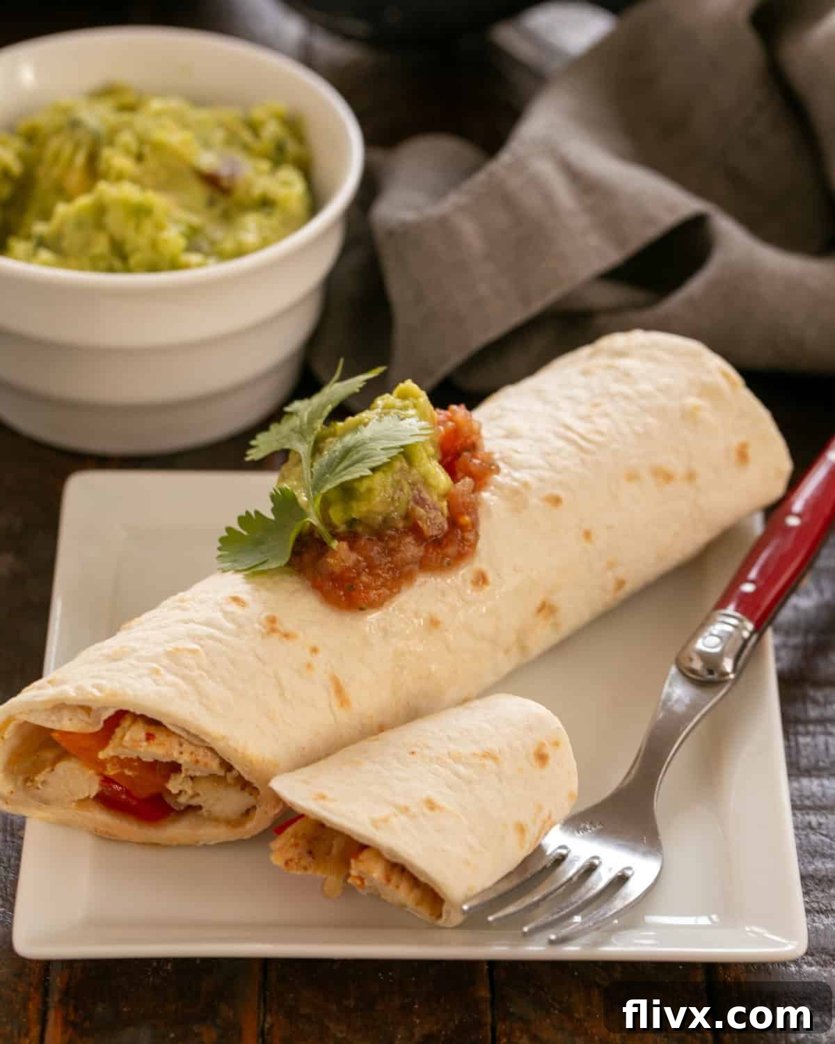 Easy Chicken Fajitas Recipe on a white plate with a red handled fork.