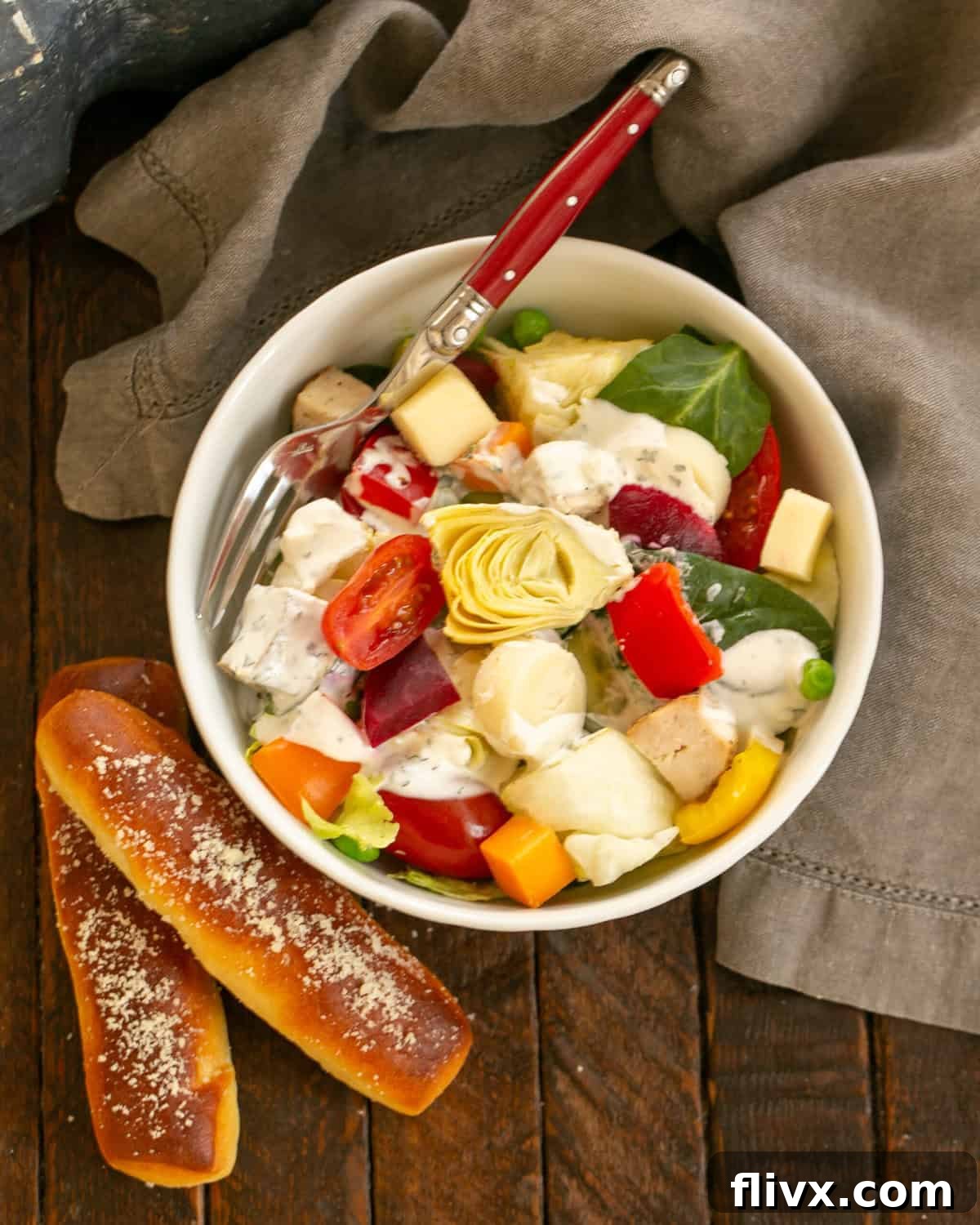 A vibrant and fresh salad bar spread with various ingredients in white bowls, ready for a home dinner party.