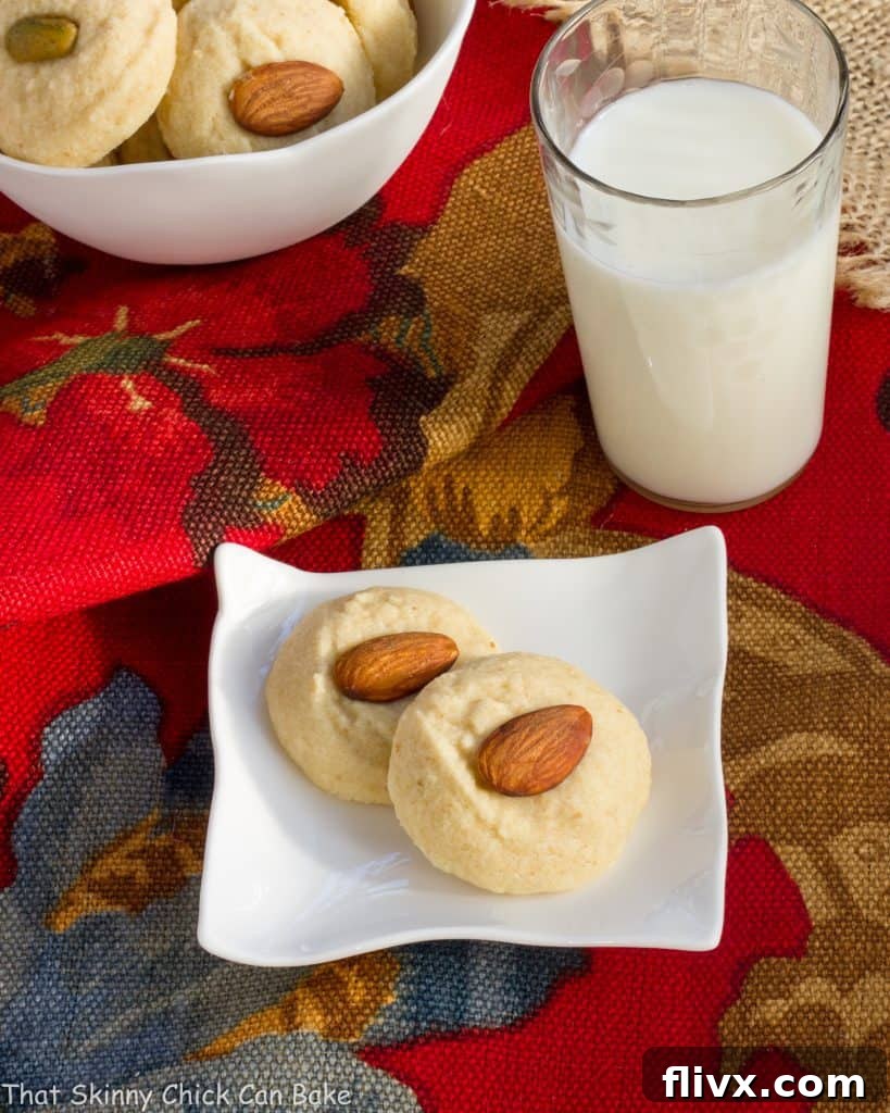 Overhead view of Ghraybeh or Lebanese Shortbread Cookies on a small white plate with a glass of milk