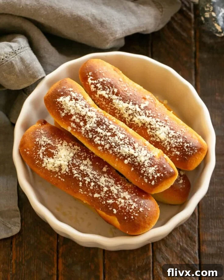 Overhead view of homemade breadsicks in a white bowl.