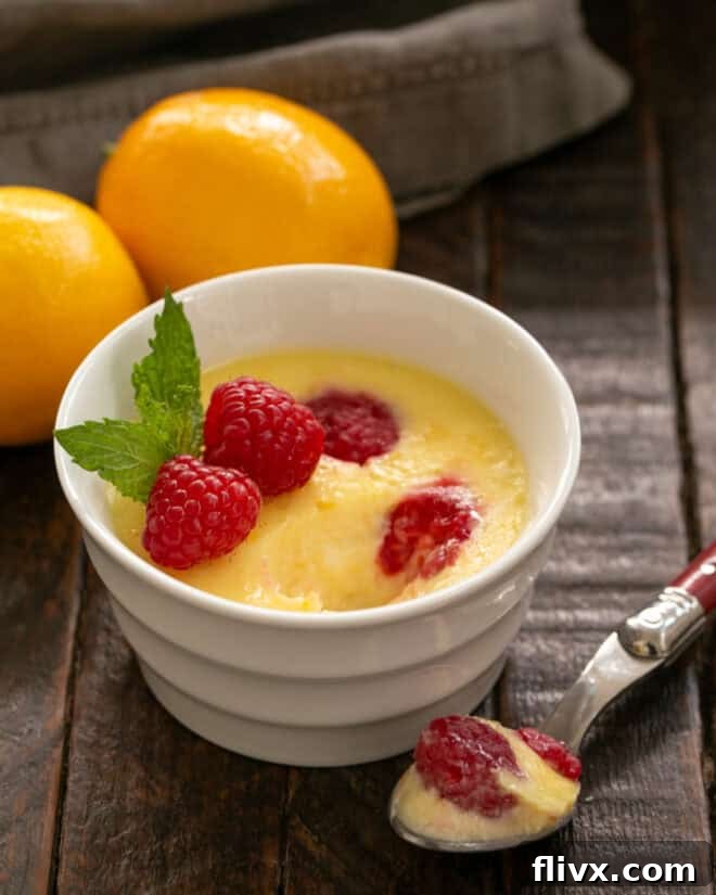 Lemon mousse with raspberries with a spoonful removed.