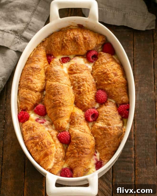 A baked Raspberry Croissant French Toast Casserole, dusted with powdered sugar, ready to be served.