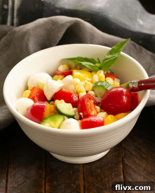 Step 4: A full serving of chopped salad in a white bowl with a fork, ready to be enjoyed.