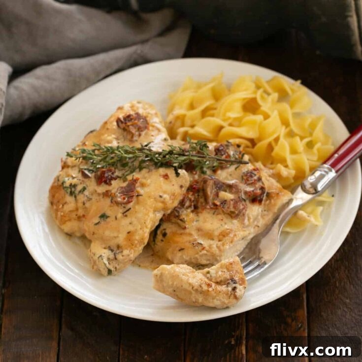 Marry Me Chicken on a white plate with pasta and a fork