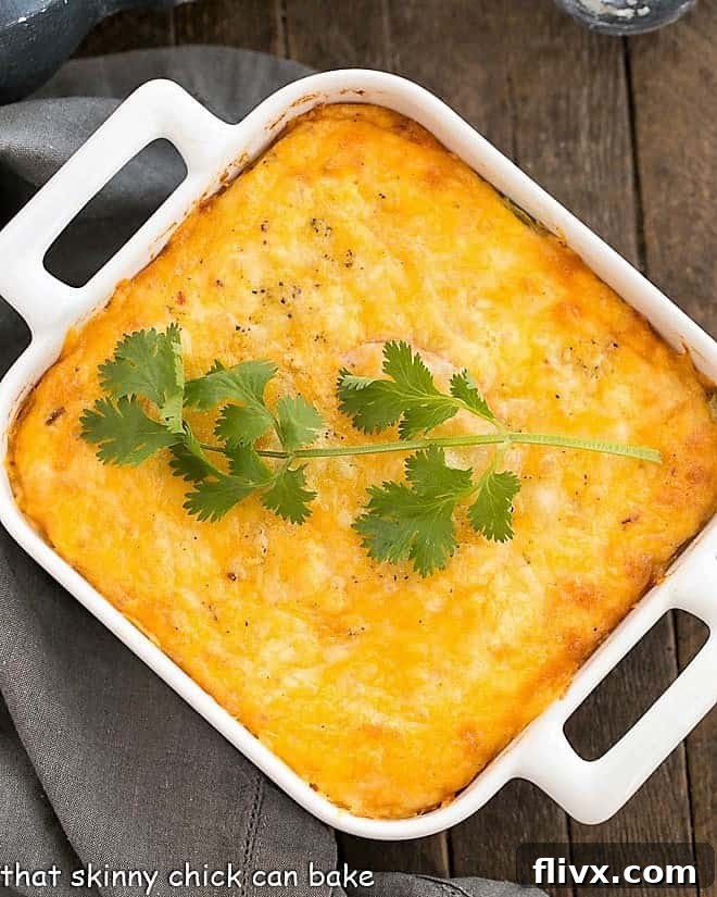 Chili Relleno Casserole in a square white baking dish, fresh from the oven and bubbling.