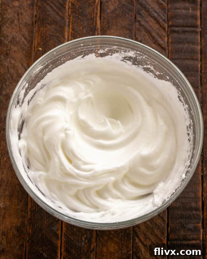 Egg whites being whipped to stiff peaks in a mixing bowl for the airy chocolate mousse.