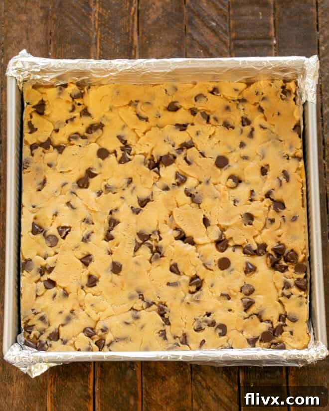 The remaining cookie dough dolloped over the caramel layer, ready for baking.