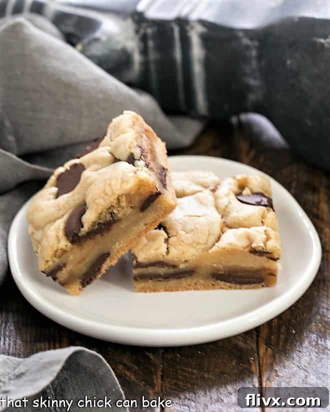Two rich caramel chocolate chip cookie bars sitting on a small round white plate, showcasing their soft texture and melted caramel.