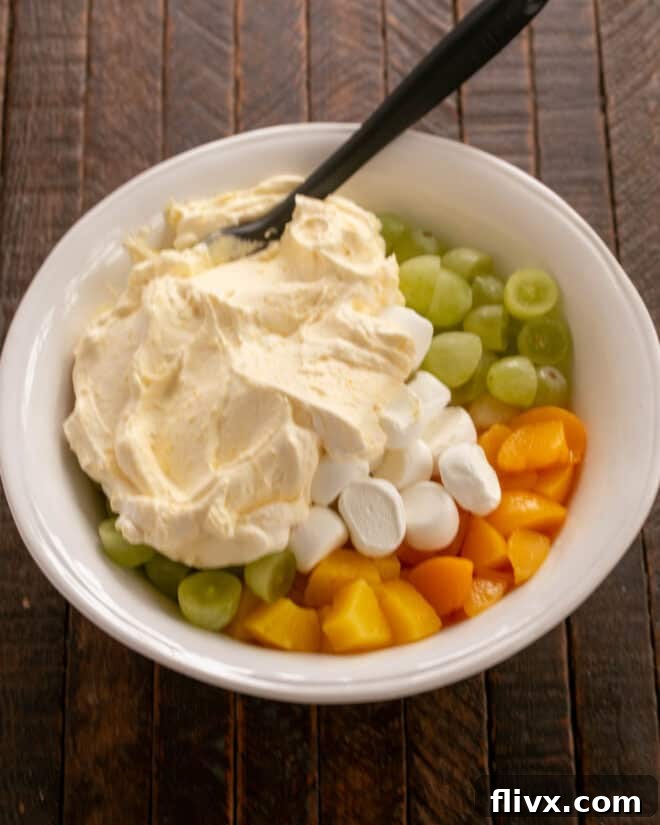Adding whipped cream dressing to fruit.