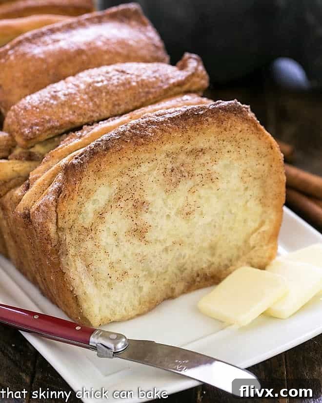 Cinnamon Pull Apart Bread on a white tray with a knife and butter pats