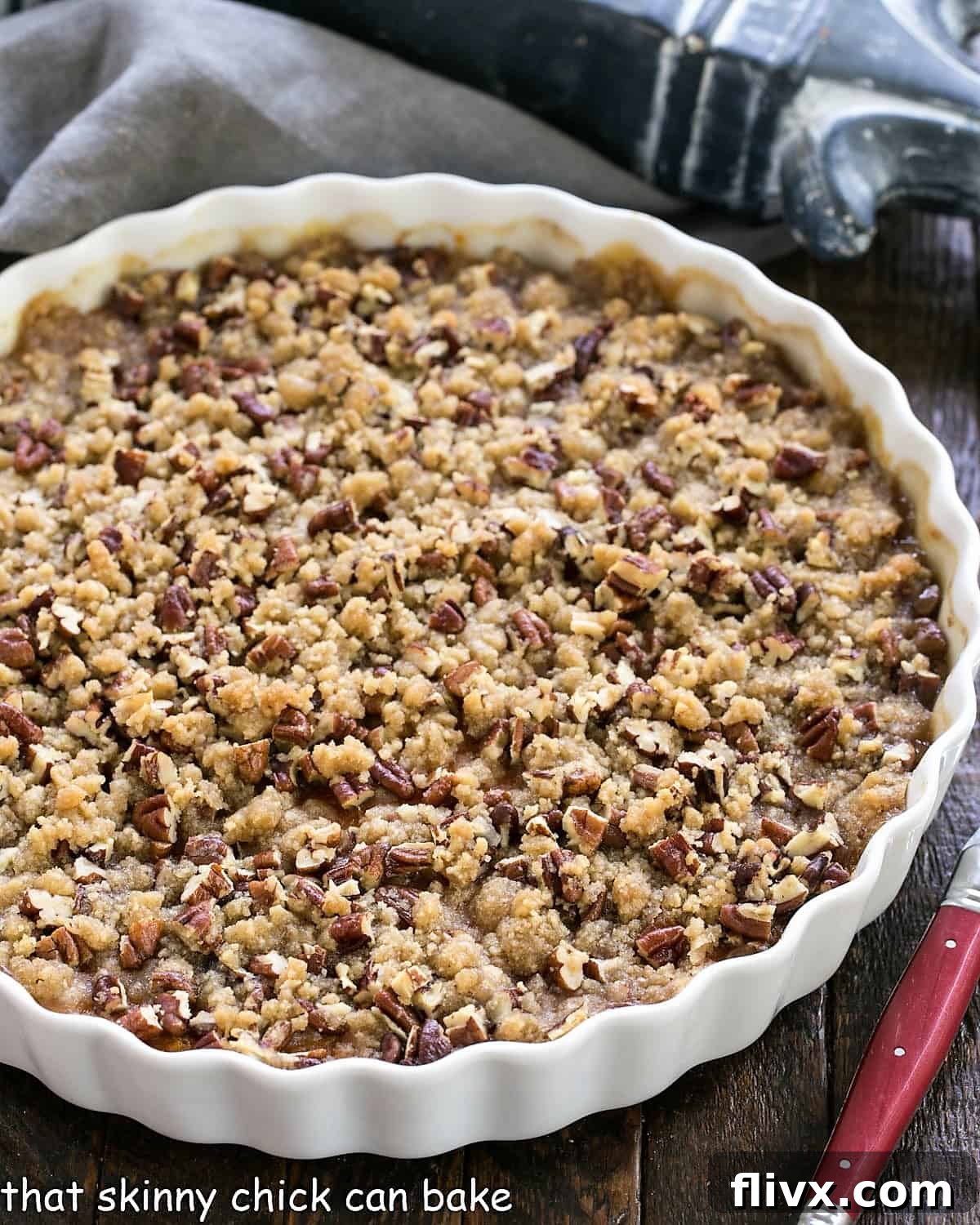 Overhead view of a perfectly baked Praline Topped Sweet Potato Casserole in a white, round baking dish, adorned with a festive title.