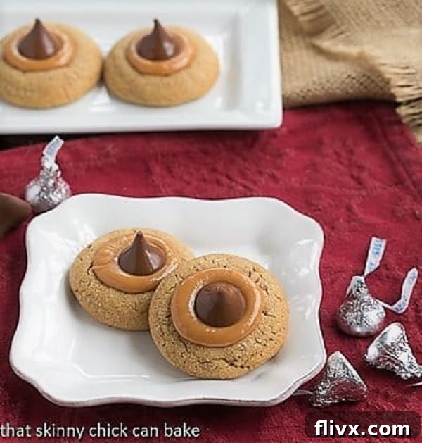Close-up of Caramel Biscoff Blossoms on a square white plate, showing the melted chocolate kiss on a bed of caramel.