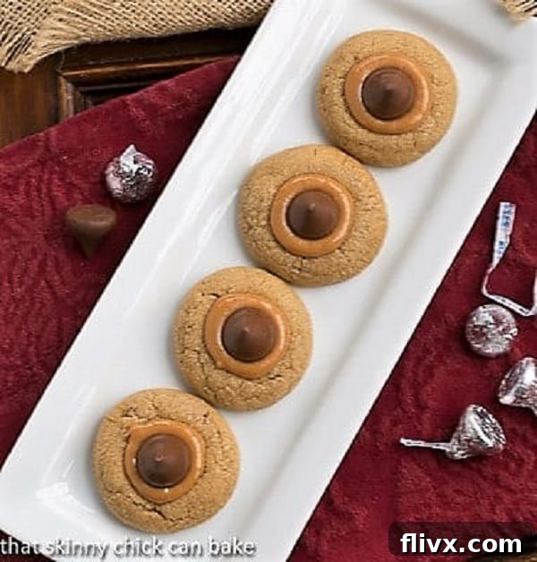 Overhead shot of Caramel Biscoff Blossoms on a rectangular white tray, showcasing a full batch of cookies with melted caramel and chocolate.