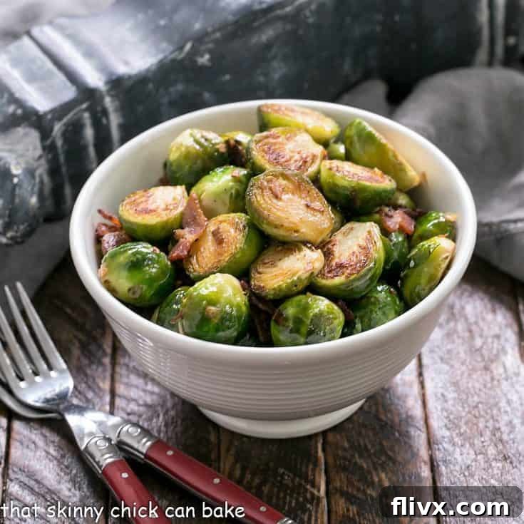 Pan brussels sprouts in a white bowl with 2 forks