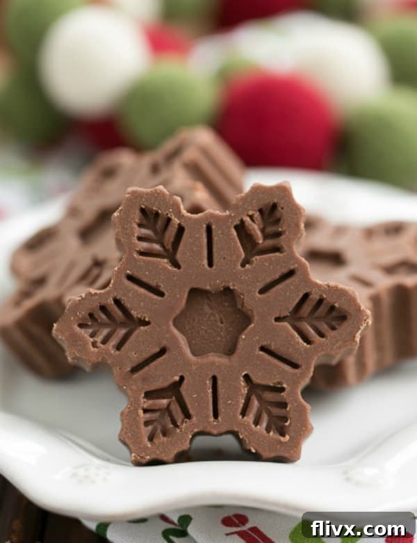 Festive Fudge Snowflakes on a white plate.