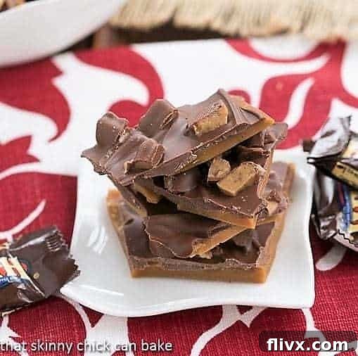 Irresistible pieces of Double Dose English Toffee, gleaming with chocolate and Heath bar chunks, presented on a small white plate.