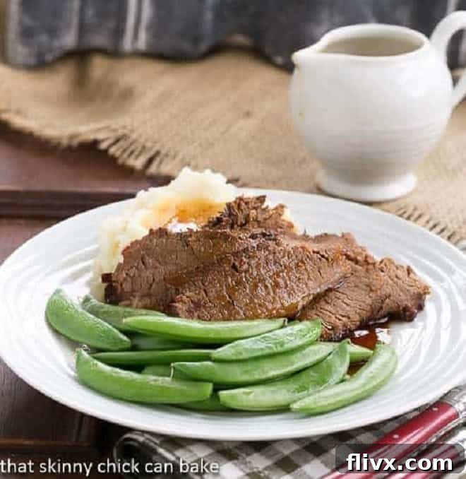 Slices of tender, dark Coffee Glazed Brisket on a white dinner plate, garnished with fresh herbs.