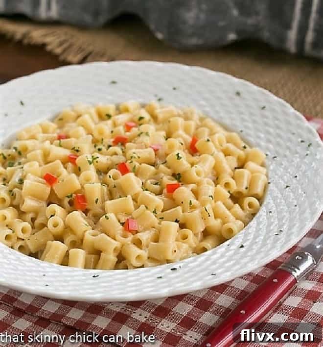 Bowl of pasta risotto with a red handled fork on a checkered napkin, showcasing the creamy texture