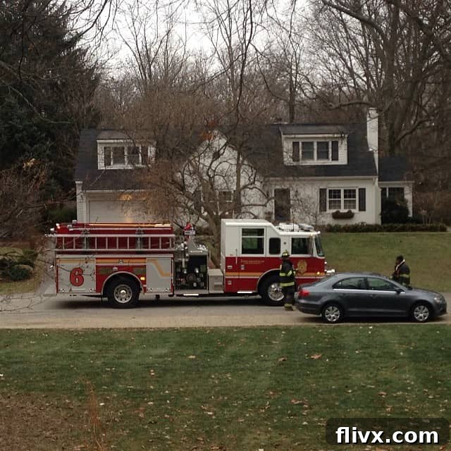 A firetruck parked in front of a house, symbolizing a kitchen mishap involving a grease fire.