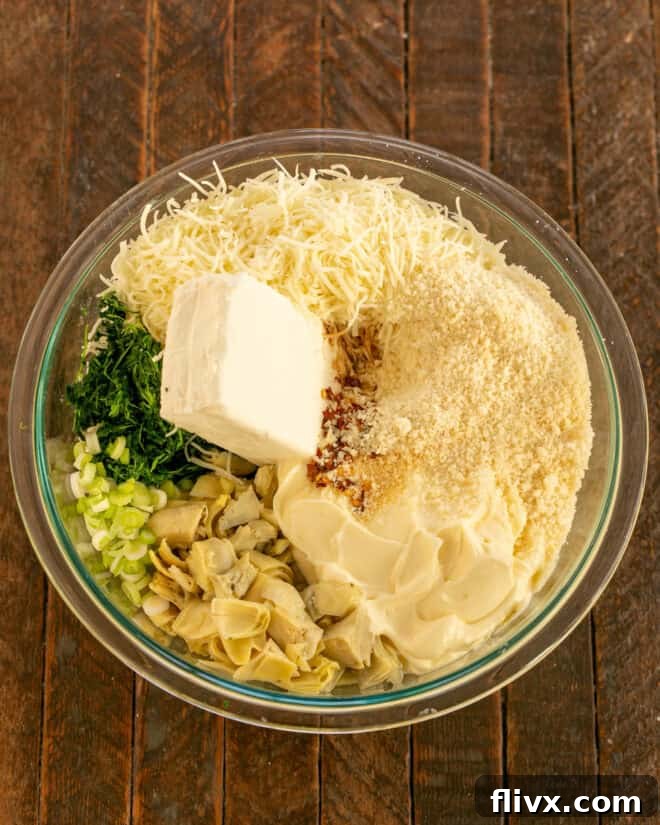Spinach artichoke dip ingredients in a mixing bowl, showcasing the fresh and creamy components before mixing.