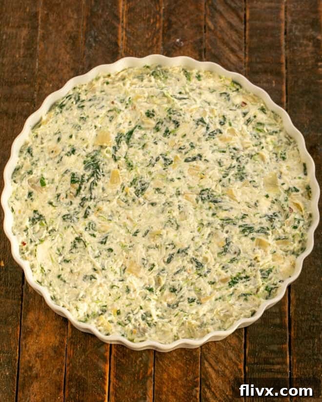 Dip in baking dish ready for the oven, perfectly spread and awaiting its golden finish.