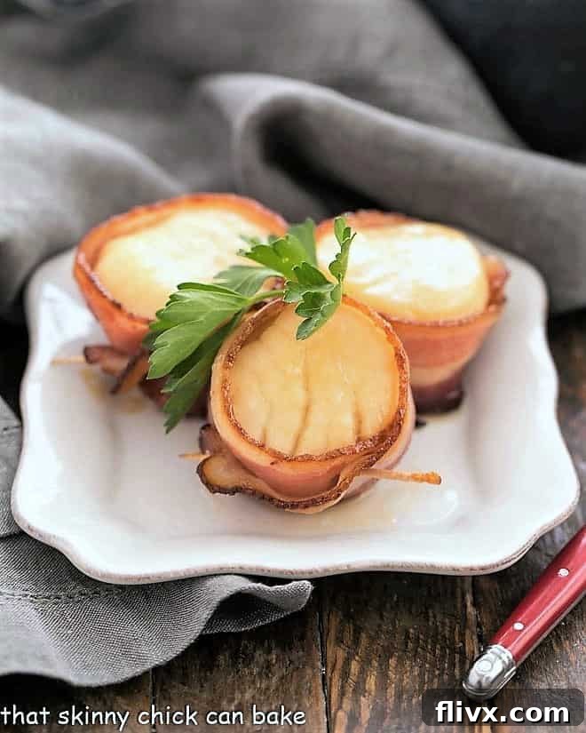 Scallops wrapped in bacon on a white appetizer plate.