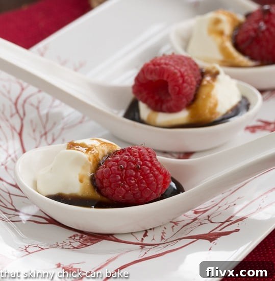 Closeup view of Balsamic Raspberries with Mascarpone Cream in white Chinese soup spoons, showcasing the layers