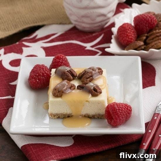 Caramel Pecan Cheesecake Bars drizzled with caramel and topped with pecans on a a square, white ceramic plate