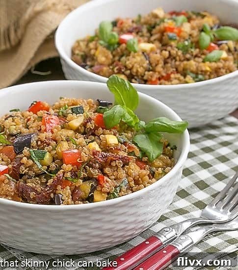 Quinoa Salad with Roasted Vegetables artfully arranged in two white bowls, garnished with fresh basil