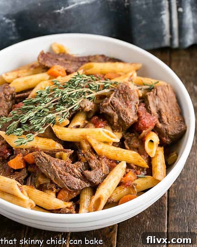 Beef Ragu Pasta - a comforting, slow-cooked dish inspired by Boeuf Bourguignon. Hearty Beef Ragu Pasta in a white serving bowl, garnished with fresh thyme for a touch of elegance.